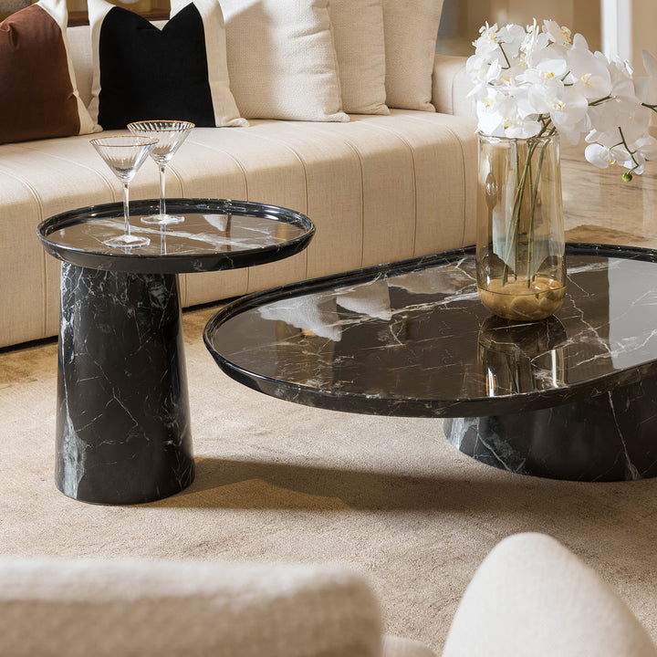 Modern living room with marble coffee table and side table, featuring a vase of white flowers.